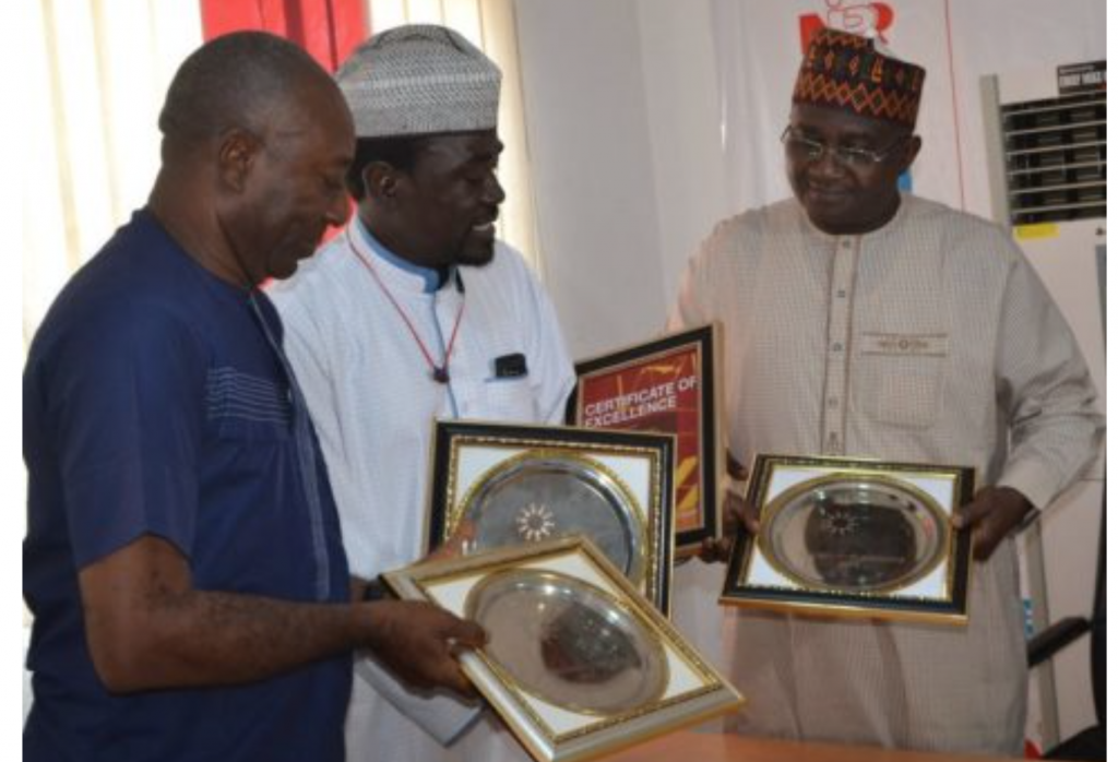 Editor-in-Chief Ewache Ajefu, and Yushau Shuaib of PRNigeria presents the multiple awards to NIPR Chief, Mukhtar